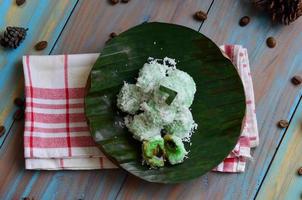 klepon ou kelepon é 1 do da indonésia tradicional bolos fez a partir de glutinoso arroz farinha que é em forma gostar pequeno bolas e preenchidas com Castanho açúcar e então fervido foto