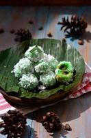 klepon ou kelepon é 1 do da indonésia tradicional bolos fez a partir de glutinoso arroz farinha que é em forma gostar pequeno bolas e preenchidas com Castanho açúcar e então fervido foto