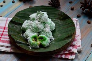 klepon ou kelepon é 1 do da indonésia tradicional bolos fez a partir de glutinoso arroz farinha que é em forma gostar pequeno bolas e preenchidas com Castanho açúcar e então fervido foto