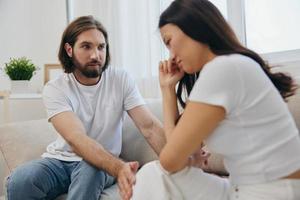 a ásia mulher é triste e chorando com dela masculino amigo às lar. estresse e mal entendido dentro uma relação entre dois pessoas e apoiando cada outros mental e emocional bem estar foto