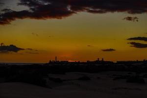 colorida pôr do sol em a espanhol ilha do vovó canaria dentro a maspalomas dunas foto