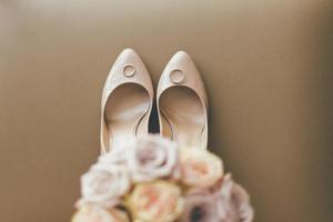 bouquet floral com sapatos de casamento e anéis foto