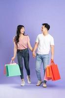 imagem do ásia casal segurando compras bolsas em roxa fundo foto