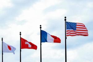 bandeiras do a EUA, França, Suíça, Japão acenando dentro a céu foto