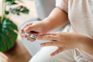 mulher corte unhas usando unha máquina de cortar cabelo, assistência médica, beleza conceito. foto