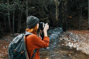 mulher turista fotografando natureza rio floresta montanhas foto