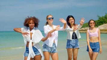 um grupo de adolescentes corre e brinca na praia nas férias de verão e sorri e aproveita as férias. foto