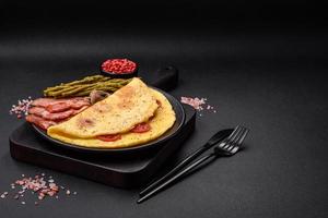 delicioso fresco omelete com cereja tomates, bacon, espargos e especiarias foto
