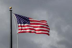 Unidos estados bandeira sopro em a vento com dramático Sombrio nublado céu foto