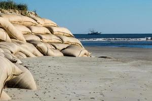 areia bolsas empilhado ao longo a costa para proteger a costa foto