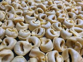 uma fechar acima topo Visão tiro do cru tortellini com branco cogumelos textura Comida fotografia foto