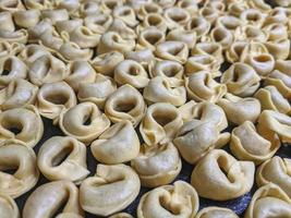 uma fechar acima topo Visão tiro do cru tortellini com branco cogumelos textura Comida fotografia foto