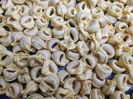 uma fechar acima topo Visão tiro do cru tortellini com branco cogumelos textura Comida fotografia foto