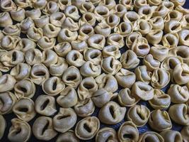 uma fechar acima topo Visão tiro do cru tortellini com branco cogumelos textura Comida fotografia foto