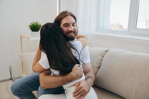 a homem abraços a menina e sorri. a alegria do usando a família e a Boa psicológico Estado depois de a brigar foto