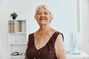 emocional velho mulher com curativo em ombro vacina Passaporte covid-19 foto