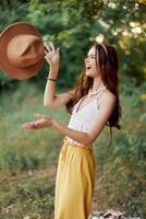 uma jovem hippie mulher dançando alegremente e sorridente sinceramente dentro natureza dentro a cair. a conceito do econômico consumo e autocuidados foto