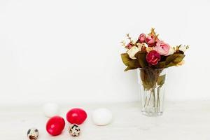 ramalhete do flores em a mesa e vermelho ovos Páscoa bichano salgueiro cristão feriado foto