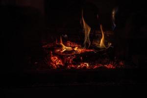 quente fogo queimando dentro uma doméstico lareira em uma inverno dia foto