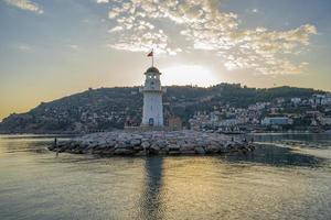 uma Maravilhoso farol às pôr do sol em a Mediterrâneo costa foto