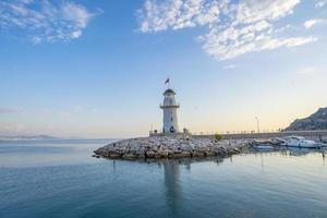 uma Maravilhoso farol às pôr do sol em a Mediterrâneo costa foto