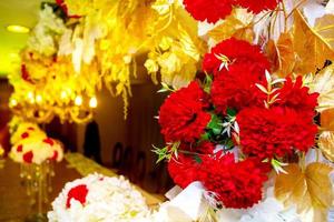 colorida vermelho e dourado flor e iluminação Casamento etapa decoração. plástico artificial flor. Casamento decoração. foto