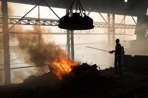 trabalhadores fundição metal restos dentro a forno do uma aço moinho para produzir varas dentro demra, daca, Bangladesh. foto