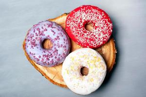 postura plana de rosquinhas variadas com geada em fundo cinza foto