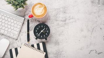 escritório escrivaninha local de trabalho com teclado, rato, caderno, caneta e copo do café, topo Visão plano deitar com cópia de espaço. foto