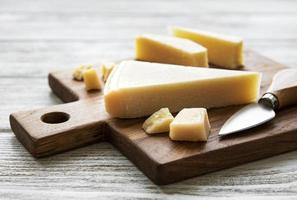 pedaço de queijo parmesão em uma placa de madeira foto