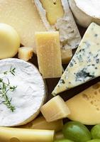 vários tipos de queijo, manjericão e uvas foto