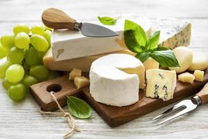 vários tipos de queijo em um fundo branco de madeira foto