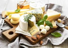 vários tipos de queijo em um fundo branco de madeira