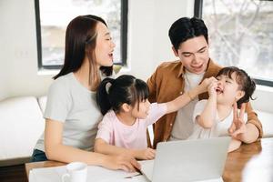 jovem ásia família às casa foto