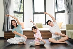 jovem ásia família exercício às casa foto