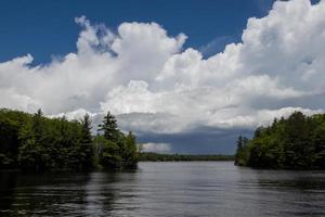 nuvens sobre uma pequeno baía cercado de árvores em uma verão dia dentro Ontário foto