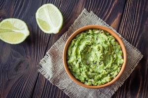 tigela de guacamole na mesa de madeira foto