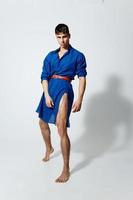 bonito cara dentro uma azul vestir em uma luz fundo dentro cheio crescimento gay modelo inflado tronco foto