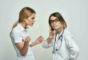 a indignado paciente comunica com uma enfermeira dentro uma médico vestido e uma seringa dentro dela mão foto