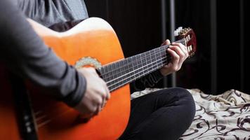 garota tocando um violão de seis cordas, close-up foto