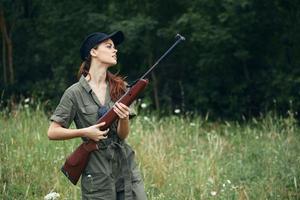 militares mulher armas dentro mão Preto boné viagem Caçando armas foto