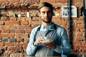 masculino garçom avental café copo tijolo parede restaurante serviço foto