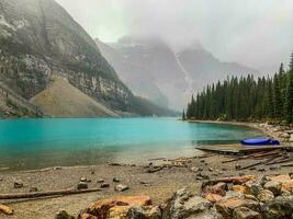 uma canoa em uma geleira alimentado lago dentro a montanhas foto