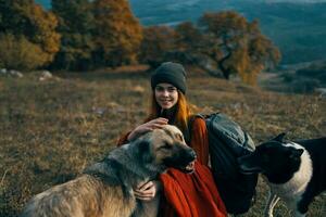 alegre mulher jogando com cachorro ao ar livre montanhas viagem período de férias foto