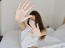 mulher gesticulando com mãos sentado em cama médico mascarar isolado quarto quarentena modelo foto
