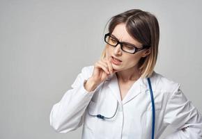 médico dentro uma médico vestido com uma estetoscópio por aí dele pescoço intrigado Veja cinzento fundo foto