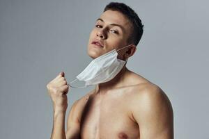 esporte cara colocando em médico mascarar em face proteção cortada Visão do saúde exercite-se foto