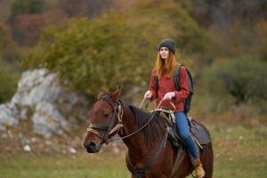 mulher caminhante equitação uma cavalo em natureza viagem foto