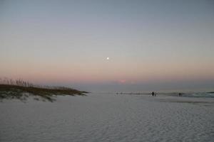 lua dentro cinzento céu a partir de a de praia foto