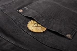 moeda bitcoin de metal no bolso da calça foto